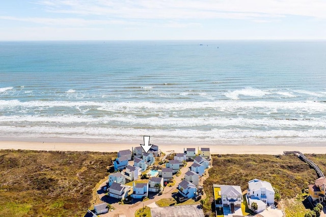 birds eye view of property with a water view and a beach view