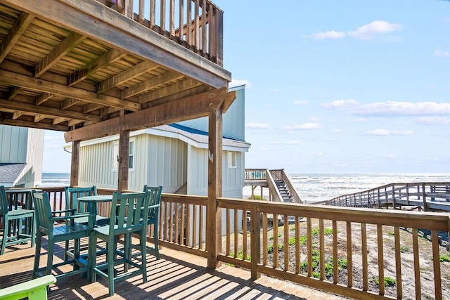 wooden deck with a view of the beach and a water view