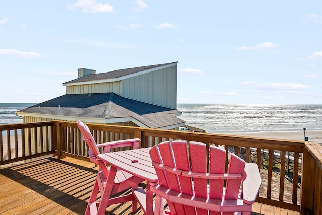 wooden deck featuring a view of the beach and a water view