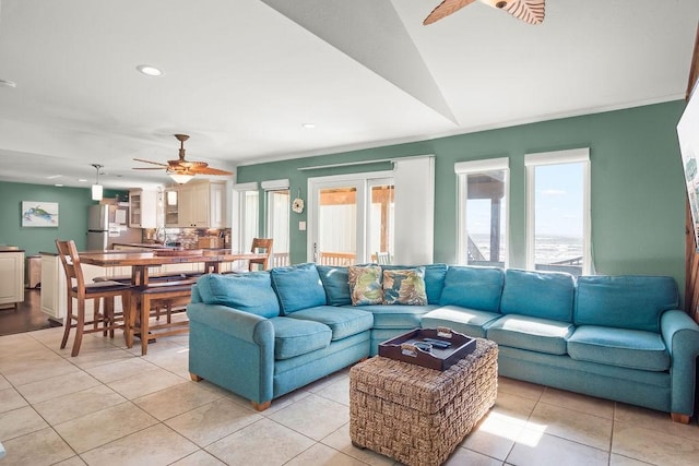 tiled living room featuring ceiling fan, sink, and lofted ceiling