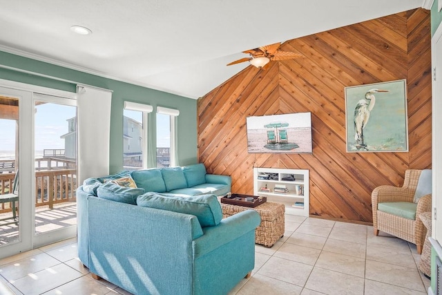 living room featuring vaulted ceiling, ceiling fan, light tile patterned flooring, and wooden walls