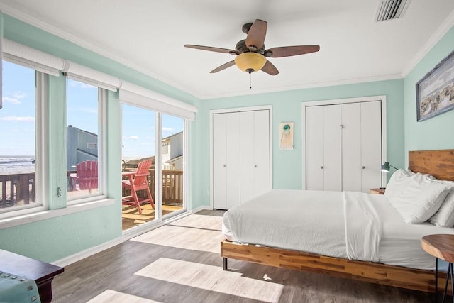 bedroom featuring ceiling fan, access to outside, wood-type flooring, multiple closets, and ornamental molding