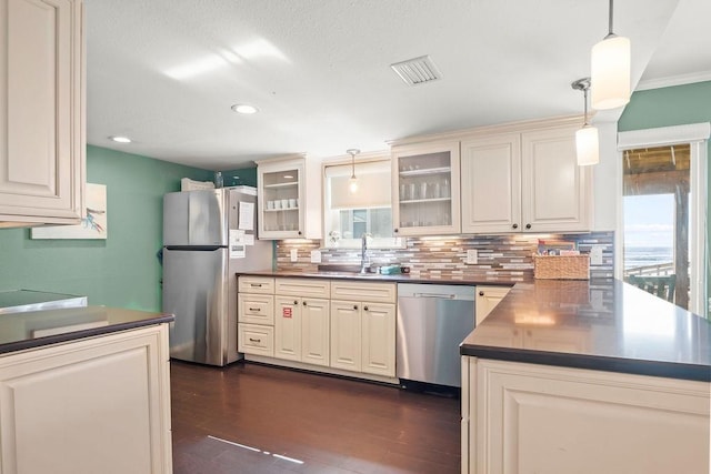 kitchen featuring stainless steel appliances, sink, hanging light fixtures, dark hardwood / wood-style floors, and ornamental molding