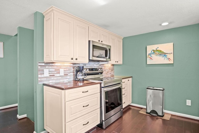 kitchen featuring dark hardwood / wood-style flooring, stainless steel appliances, cream cabinets, and tasteful backsplash