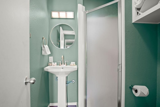 bathroom featuring sink and an enclosed shower