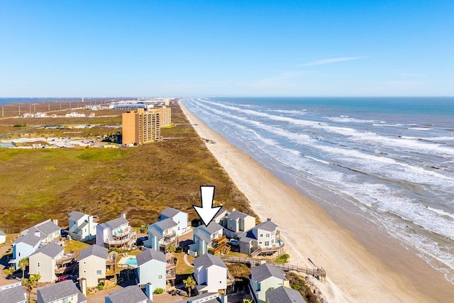 birds eye view of property with a water view and a beach view