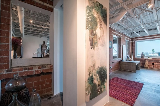 bathroom featuring concrete floors and brick wall