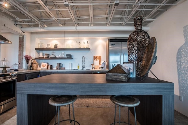 bar with concrete floors, sink, and appliances with stainless steel finishes