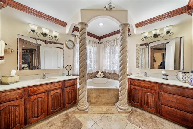 bathroom featuring decorative columns, vanity, tiled bath, and crown molding