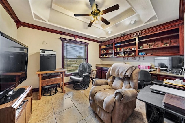 tiled office featuring a tray ceiling, built in desk, ornamental molding, and ceiling fan