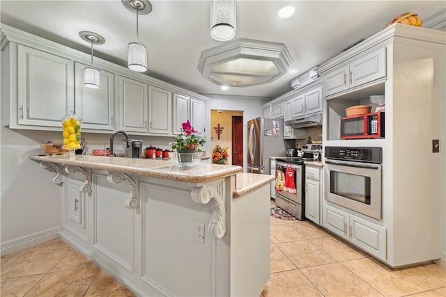 kitchen with a kitchen bar, decorative light fixtures, kitchen peninsula, and appliances with stainless steel finishes