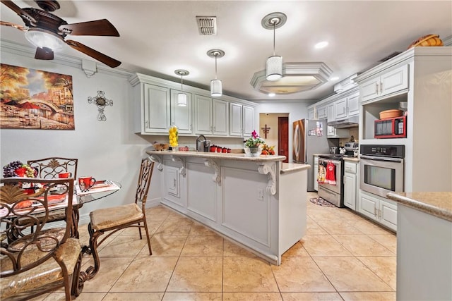 kitchen with light tile patterned floors, a breakfast bar, white cabinetry, stainless steel appliances, and kitchen peninsula