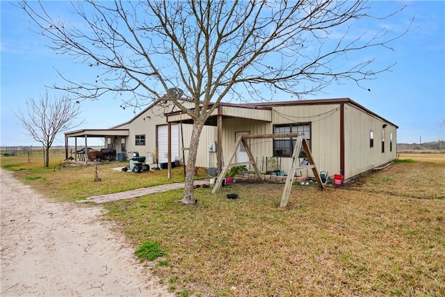 exterior space with a garage and a lawn