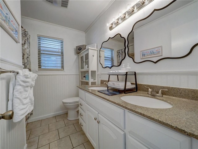 bathroom with toilet, vanity, tile patterned flooring, and crown molding