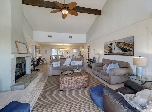 living room featuring ceiling fan with notable chandelier, light hardwood / wood-style floors, beam ceiling, and high vaulted ceiling