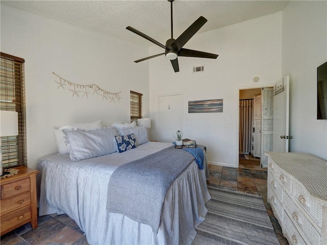 bedroom with ceiling fan, a textured ceiling, and high vaulted ceiling