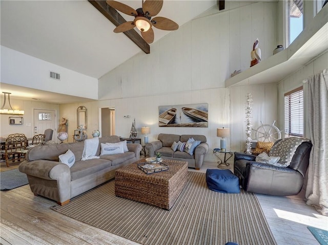 living room featuring ceiling fan, high vaulted ceiling, beamed ceiling, and hardwood / wood-style flooring