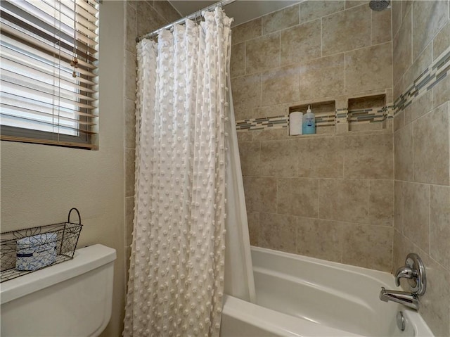 bathroom featuring shower / bath combo with shower curtain and toilet