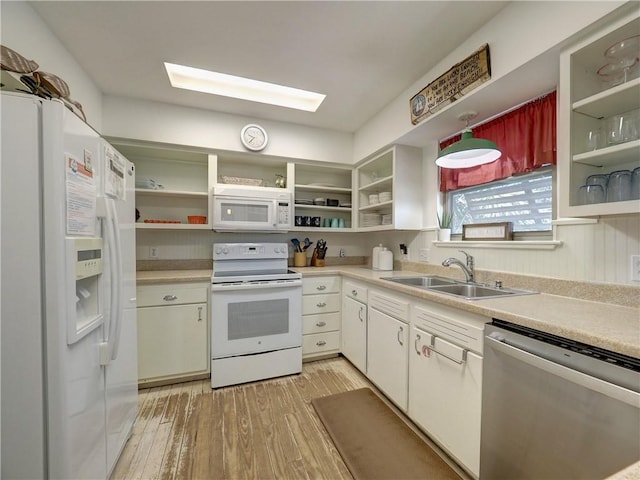 kitchen with sink, light hardwood / wood-style floors, white cabinets, and white appliances