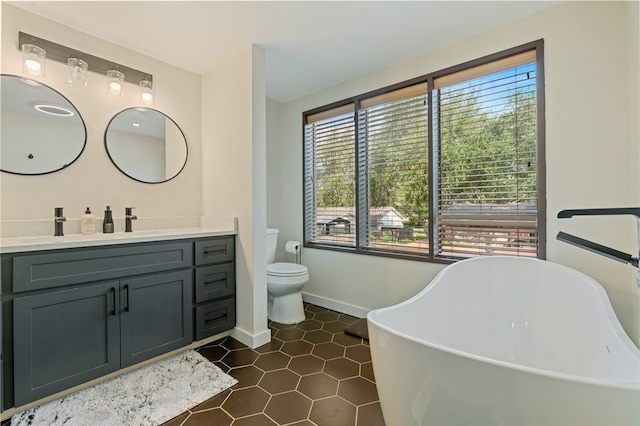 bathroom featuring toilet, a tub to relax in, vanity, and tile patterned floors