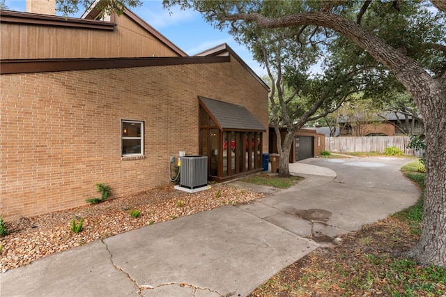 view of side of property featuring central air condition unit and a garage