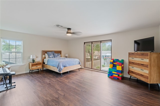 bedroom with access to exterior, multiple windows, and dark hardwood / wood-style floors