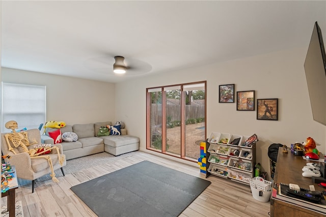 living room with light hardwood / wood-style floors and ceiling fan