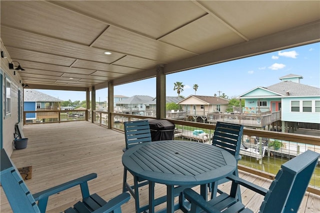 wooden deck with outdoor dining space, area for grilling, and a residential view