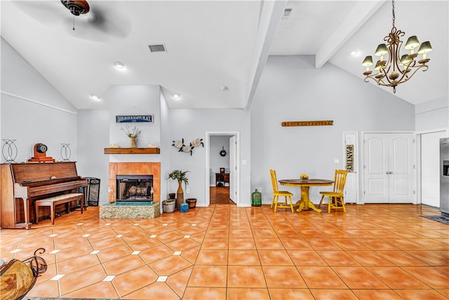 living room featuring light tile patterned flooring, ceiling fan with notable chandelier, beam ceiling, high vaulted ceiling, and a tile fireplace