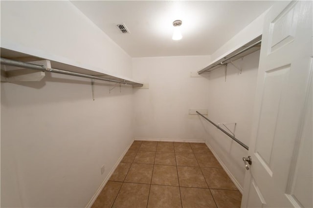 spacious closet featuring dark tile patterned floors