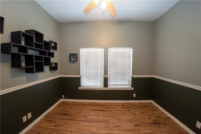 empty room featuring ceiling fan, plenty of natural light, and hardwood / wood-style flooring