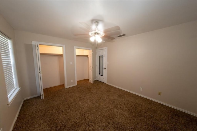 unfurnished bedroom with dark carpet and ceiling fan