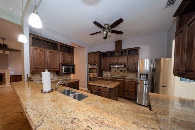 kitchen featuring sink, backsplash, decorative light fixtures, dark brown cabinets, and appliances with stainless steel finishes