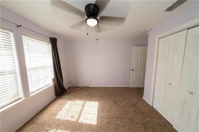 unfurnished bedroom featuring carpet flooring, ceiling fan, and a closet