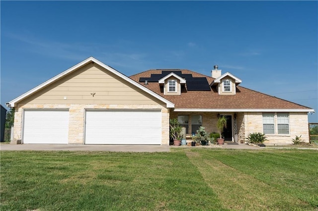 view of front of house with solar panels, a garage, and a front yard