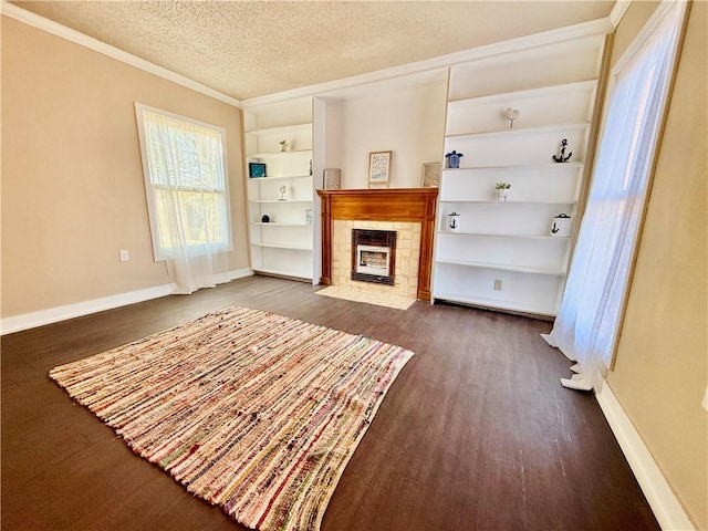 unfurnished living room with dark wood-style floors, baseboards, built in features, and a textured ceiling