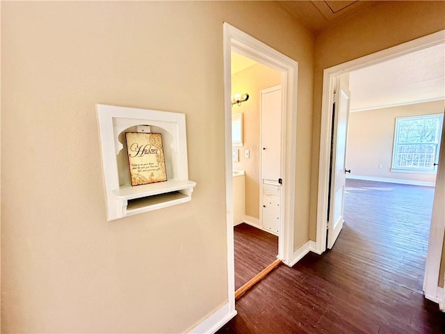 corridor featuring dark wood-style flooring and baseboards