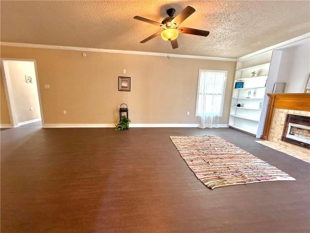 living area featuring baseboards, dark wood finished floors, a tile fireplace, ornamental molding, and a textured ceiling