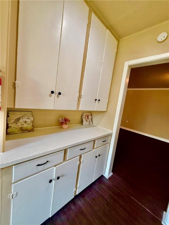 kitchen with dark wood-style floors, light countertops, and white cabinets