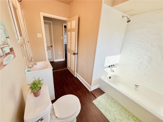 full bathroom with baseboards, toilet, shower / tub combination, wood finished floors, and a sink