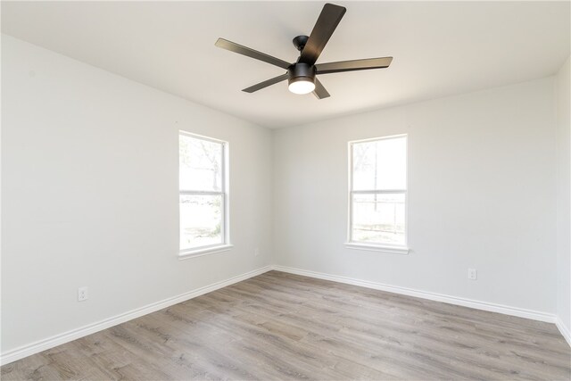 empty room featuring ceiling fan, a healthy amount of sunlight, and light hardwood / wood-style flooring