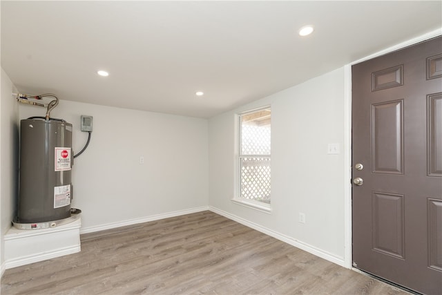 interior space featuring electric water heater and light hardwood / wood-style floors