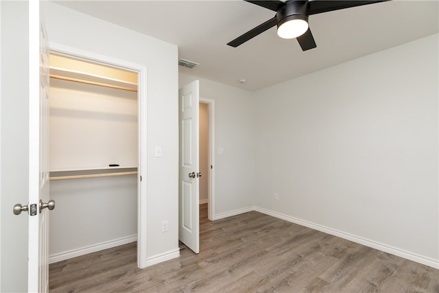 unfurnished bedroom featuring a closet, light hardwood / wood-style floors, and ceiling fan