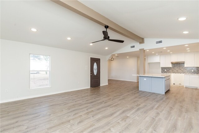 unfurnished living room featuring lofted ceiling with beams, light hardwood / wood-style floors, and ceiling fan