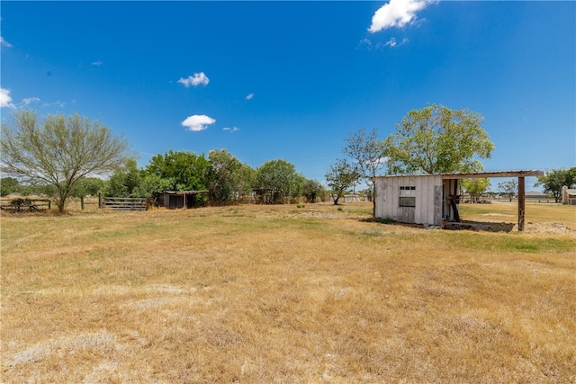 view of yard featuring a rural view and a storage shed