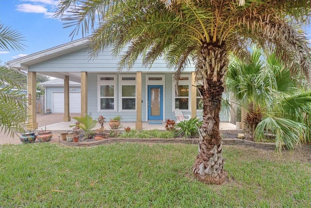 view of front of home featuring a garage, covered porch, and a front lawn