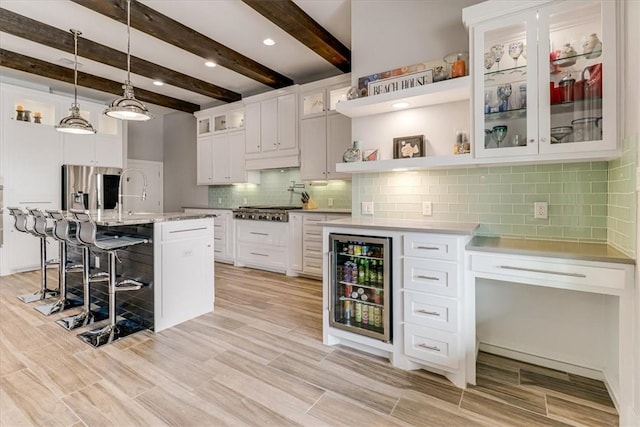 bar featuring tasteful backsplash, beverage cooler, hanging light fixtures, stainless steel appliances, and beam ceiling