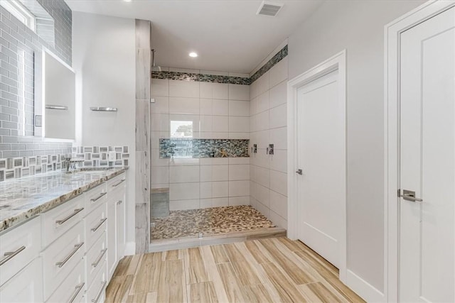 full bathroom with recessed lighting, wood finished floors, walk in shower, vanity, and visible vents