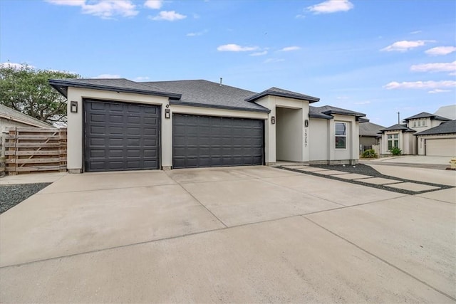 prairie-style home with concrete driveway, a garage, stucco siding, and fence