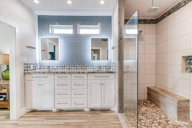 bathroom featuring a walk in shower, wood tiled floor, and double vanity